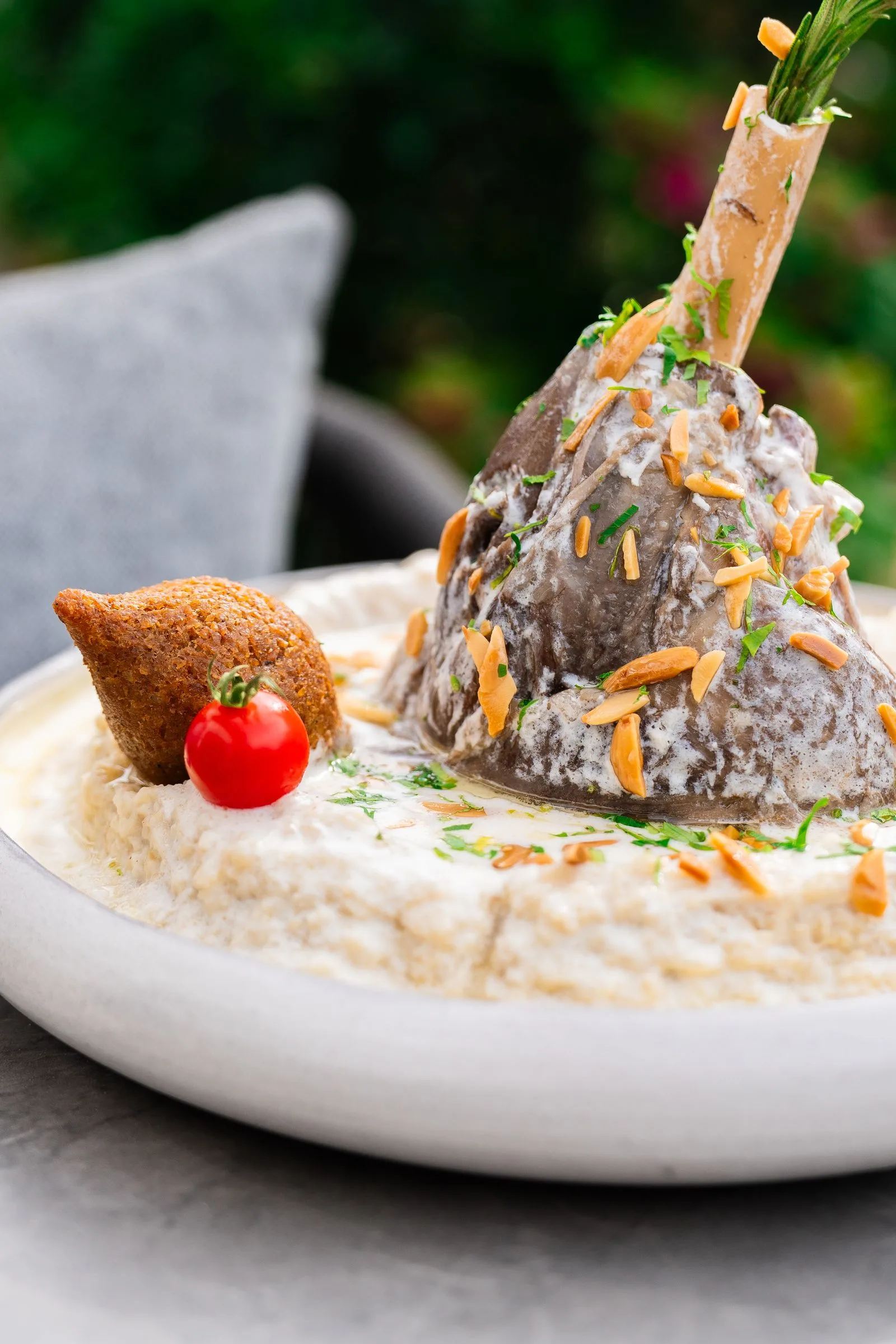 غذاهای اماراتی؛ ۱۲ خوراک سنتی که در سفر به دبی باید امتحان کنید 1 emirati machboos lamb dish with hummus served in dubai