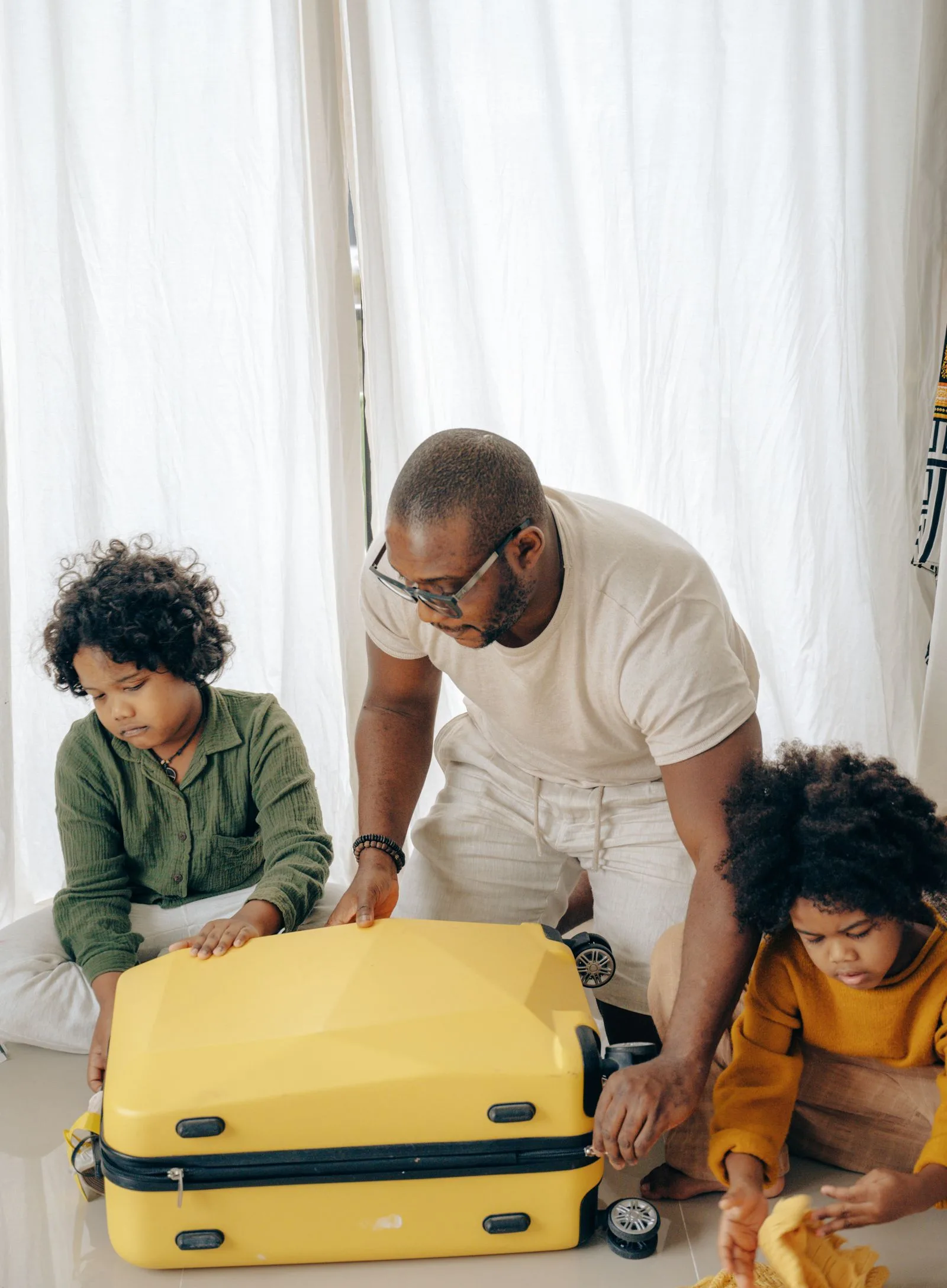 معافیت ویزای فرزندان زیر ۱۸ سال امارات؛ شرایط و نحوهی استفاده (تابستان ۲۰۲۶) 1 father and children packing luggage travel preparation